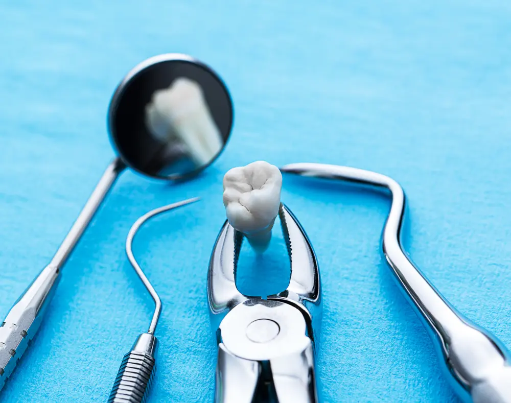 A dental mirror and dental tools surround a dental implant tooth on a blue background, with the mirror reflecting the same implant.
